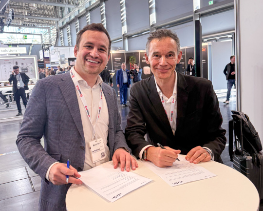 2 business people sign a document