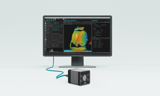 3D camera in front of a monitor displaying a colored point cloud and a software interface
