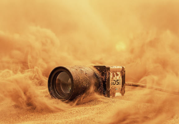 IDS industrial camera in sand amid dust clouds