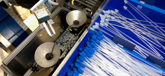 A robot sorts catheters with blue and white attachments using an Ensenso 3D camera.