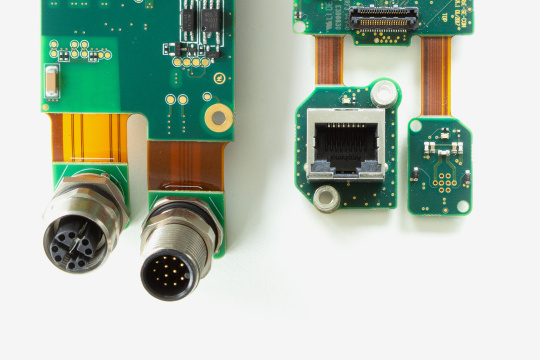 Detailed view of two small board level cameras with different plugs.