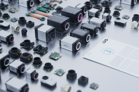 Housing and board-level cameras arranged in rows showcase IDS-branded industrial cameras