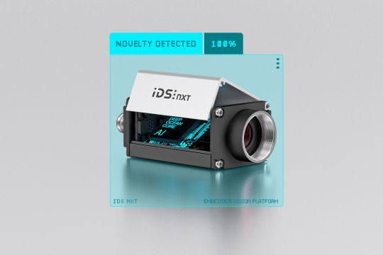 IDS NXT with open housing, with “AI” in neon lettering. Camera in a blue frame and the lettering “novelty detected 100%”