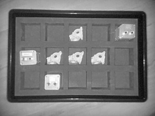 A grayscale intensity image from the Nion 3D camera shows various objects in a box with sorting trays from a top view.