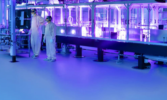 Two employees in protective clothing inside a research laser