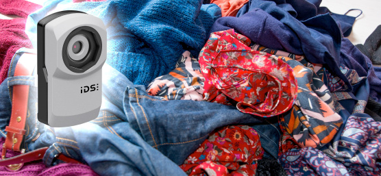 uEye XC camera hovers in front of a mountain of old clothes