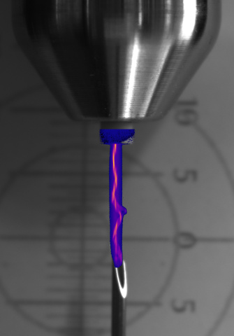 A vertical, slender light trail beneath a metallic component, overlaid with color