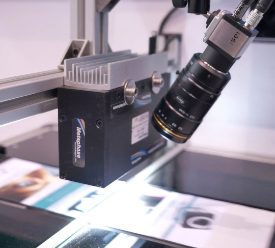 IDS uEye camera with lens observes a production of printed paper