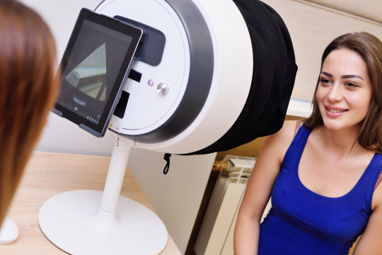 Woman sitting in front of medical device with tablet on the back.