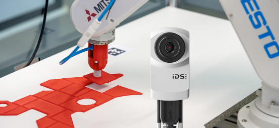 Robot arm places red puzzle piece in exactly the right place, uEye XC camera in the foreground