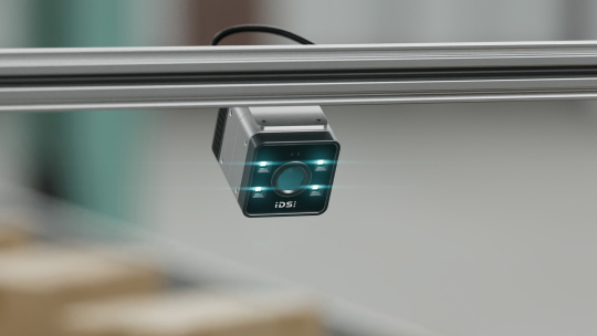 Compact camera beneath a metal rail in an industrial setting
