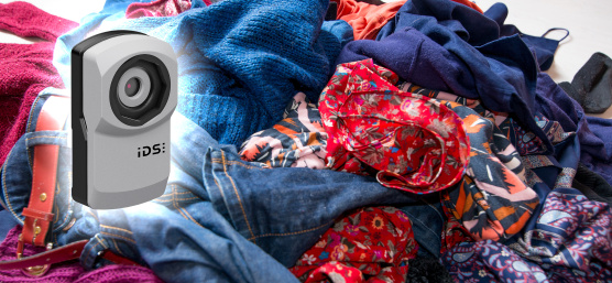 uEye XC camera in front of a mountain of old clothes