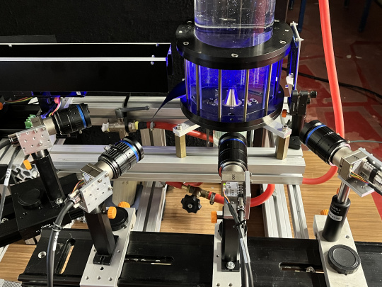 Test setup with multiple EVS industrial cameras for 3D flow diagnostics on a transparent container