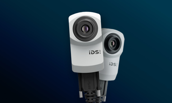 Two IDS uEye SC industrial cameras on blue background.